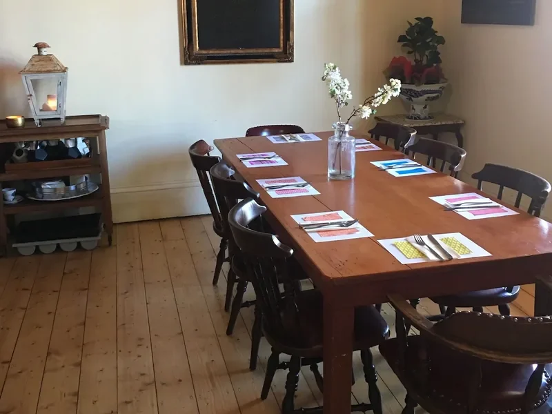The dining room, with a long timber table set on the floorboards